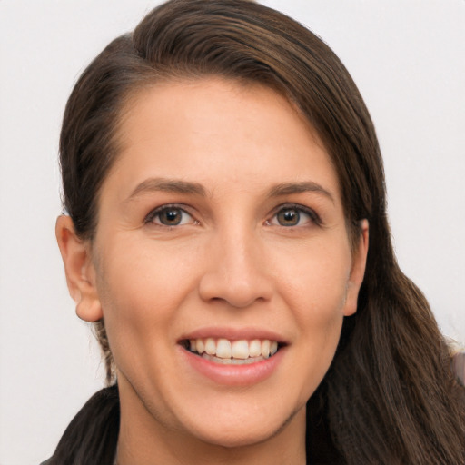 Joyful white young-adult female with long  brown hair and brown eyes