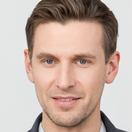 Joyful white young-adult male with short  brown hair and grey eyes