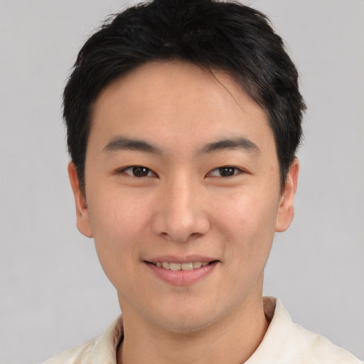 Joyful asian young-adult male with short  brown hair and brown eyes