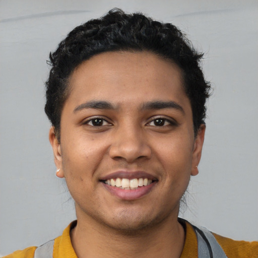 Joyful latino young-adult male with short  black hair and brown eyes