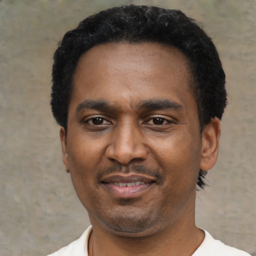Joyful latino adult male with short  black hair and brown eyes