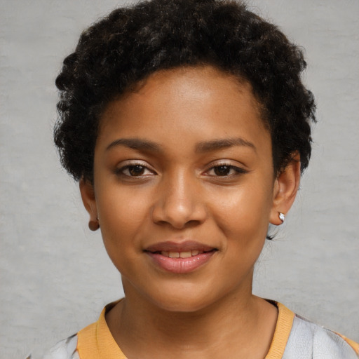 Joyful black young-adult female with short  black hair and brown eyes