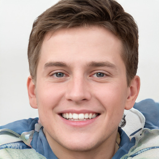 Joyful white young-adult male with short  brown hair and blue eyes