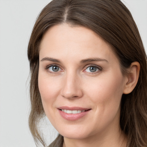 Joyful white young-adult female with long  brown hair and grey eyes