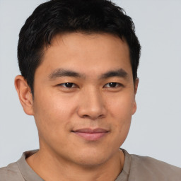 Joyful asian young-adult male with short  brown hair and brown eyes