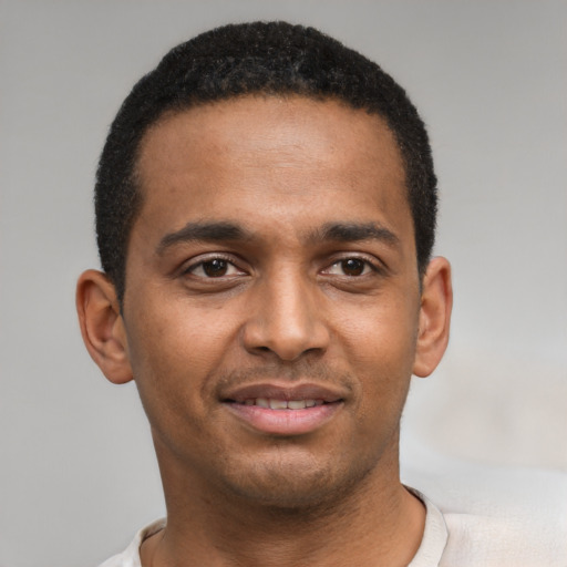 Joyful black young-adult male with short  brown hair and brown eyes