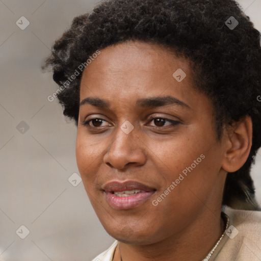 Joyful black young-adult female with short  black hair and brown eyes