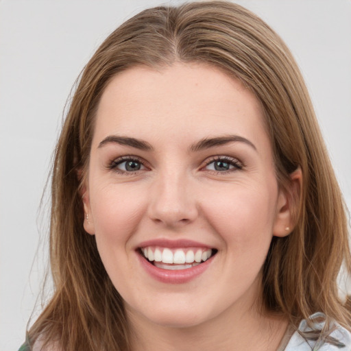 Joyful white young-adult female with medium  brown hair and green eyes