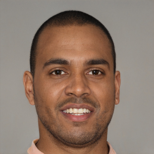 Joyful black young-adult male with short  brown hair and brown eyes