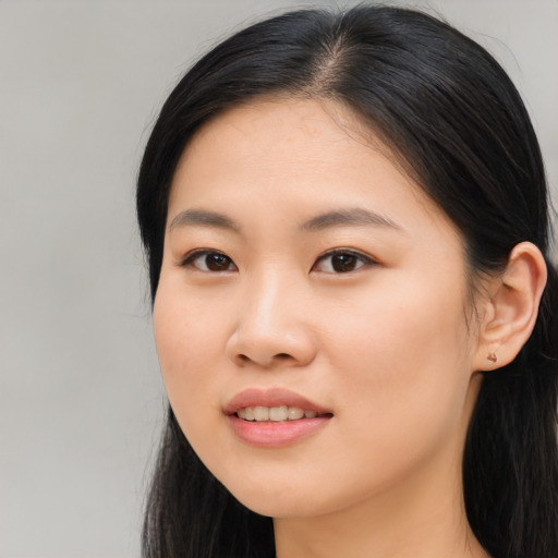 Joyful asian young-adult female with long  black hair and brown eyes