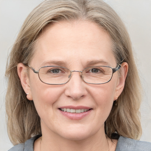 Joyful white adult female with medium  brown hair and blue eyes