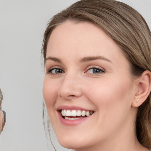 Joyful white young-adult female with medium  brown hair and blue eyes