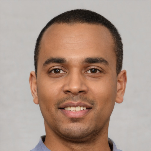 Joyful latino young-adult male with short  brown hair and brown eyes