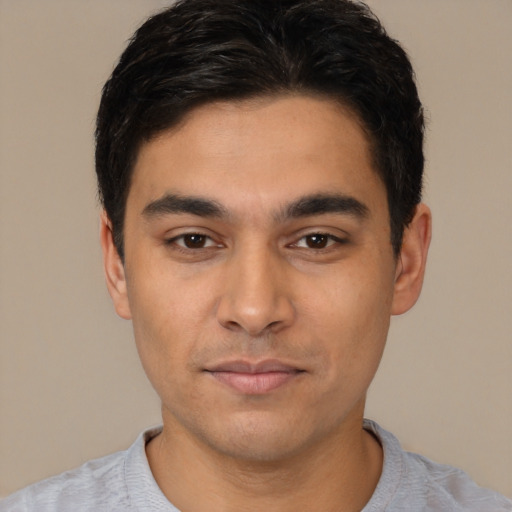Joyful latino young-adult male with short  black hair and brown eyes