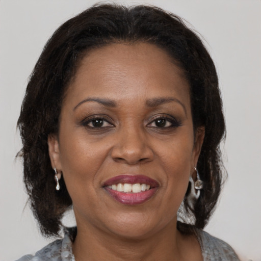 Joyful latino adult female with medium  brown hair and brown eyes