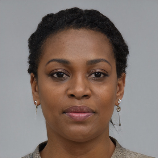 Joyful black young-adult female with short  black hair and brown eyes