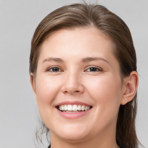 Joyful white young-adult female with medium  brown hair and grey eyes