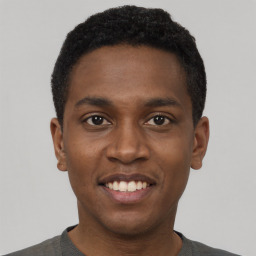 Joyful black young-adult male with short  black hair and brown eyes