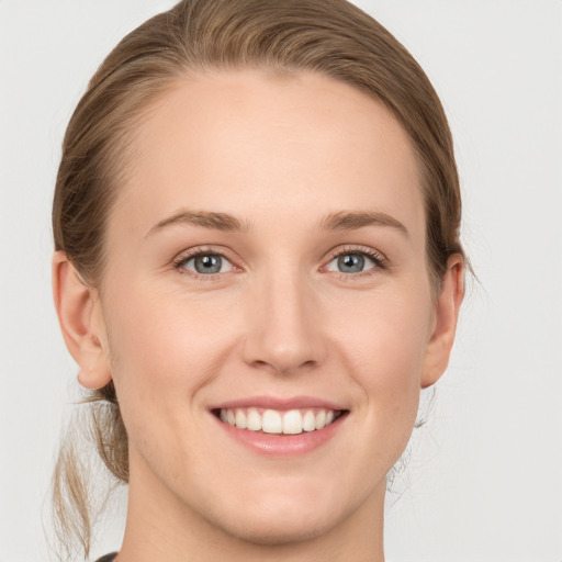 Joyful white young-adult female with medium  brown hair and blue eyes