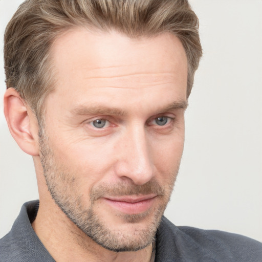 Joyful white adult male with short  brown hair and grey eyes