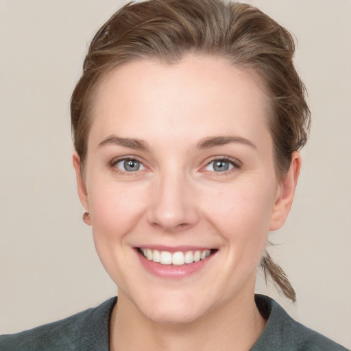 Joyful white young-adult female with short  brown hair and grey eyes