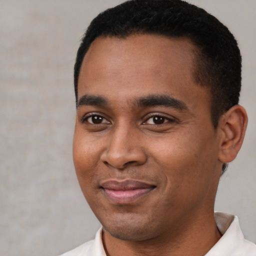 Joyful latino young-adult male with short  black hair and brown eyes