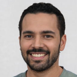 Joyful latino young-adult male with short  black hair and brown eyes