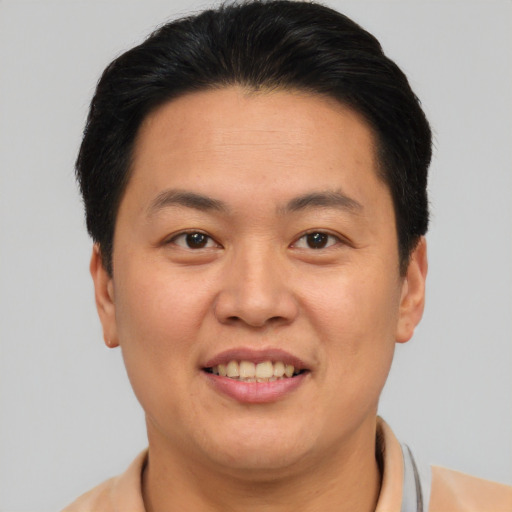 Joyful asian young-adult male with short  brown hair and brown eyes