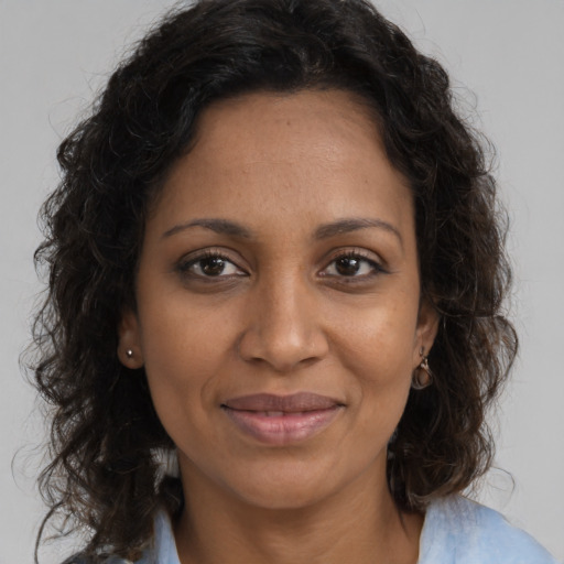 Joyful black adult female with long  brown hair and brown eyes