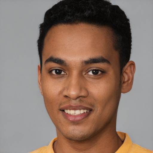 Joyful black young-adult male with short  black hair and brown eyes