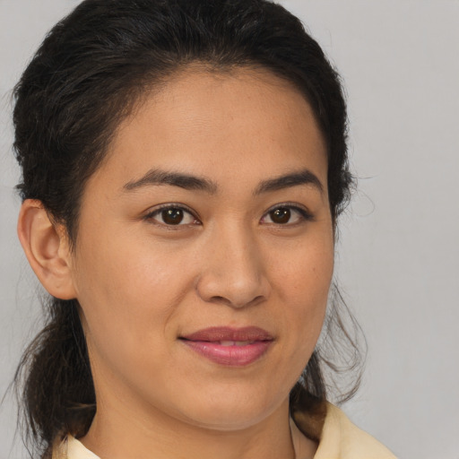 Joyful latino young-adult female with medium  brown hair and brown eyes