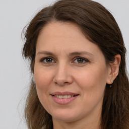 Joyful white adult female with long  brown hair and brown eyes