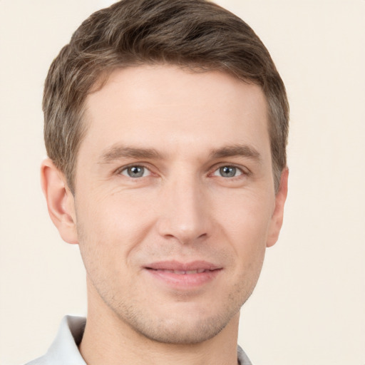 Joyful white young-adult male with short  brown hair and grey eyes