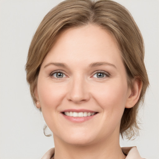 Joyful white young-adult female with medium  brown hair and grey eyes