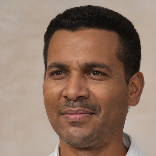 Joyful black adult male with short  black hair and brown eyes