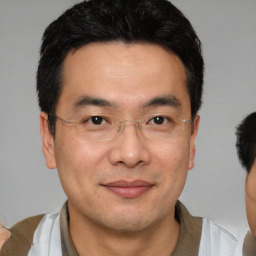 Joyful white adult male with short  black hair and brown eyes