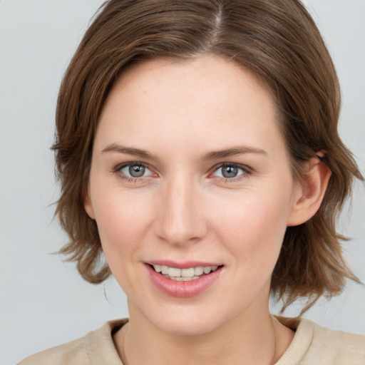 Joyful white young-adult female with medium  brown hair and grey eyes