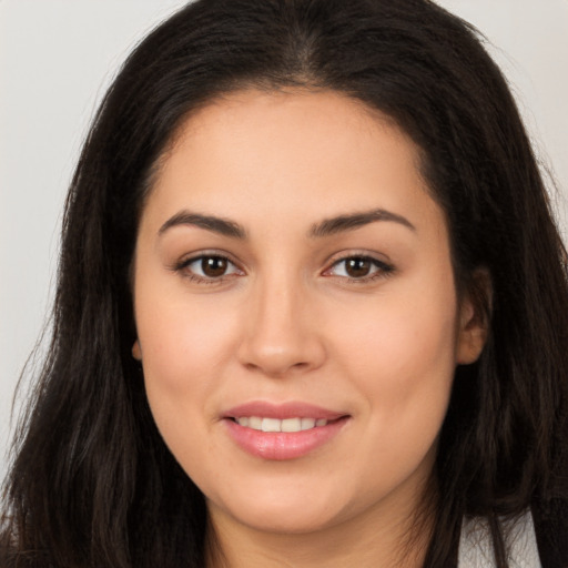 Joyful latino young-adult female with long  brown hair and brown eyes