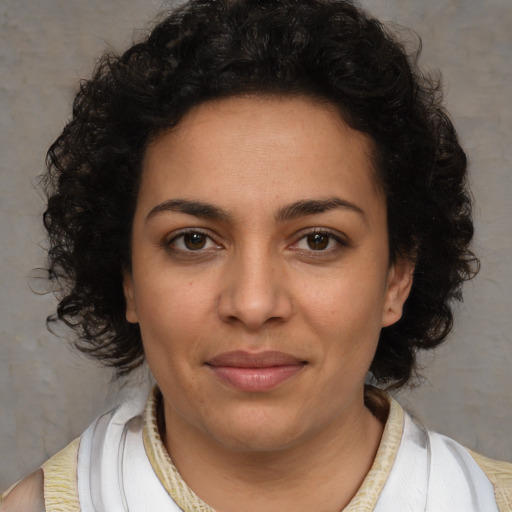 Joyful latino young-adult female with medium  brown hair and brown eyes