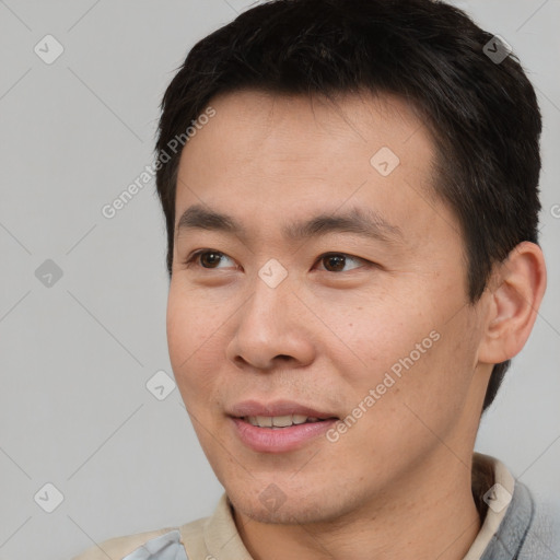 Joyful asian adult male with short  brown hair and brown eyes