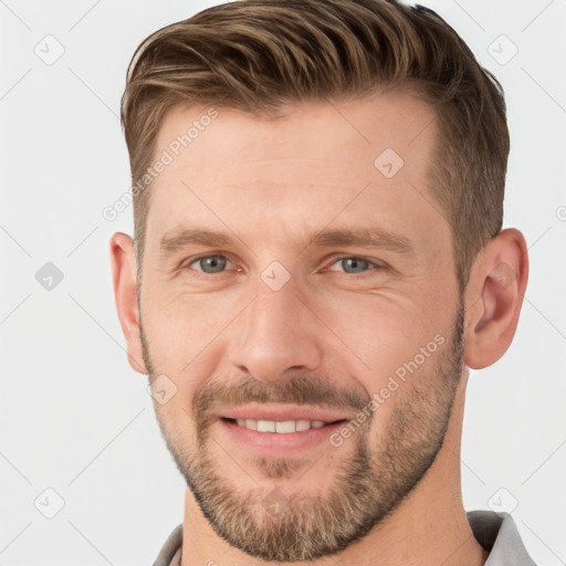 Joyful white adult male with short  brown hair and grey eyes