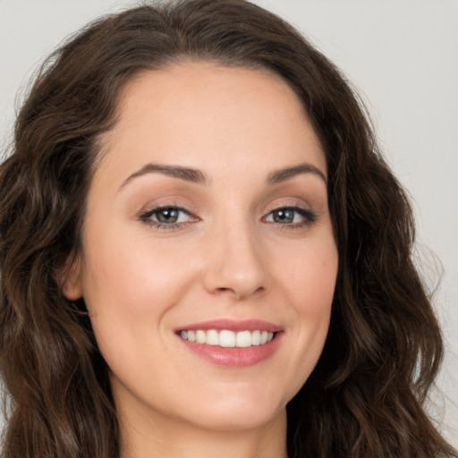 Joyful white young-adult female with long  brown hair and brown eyes