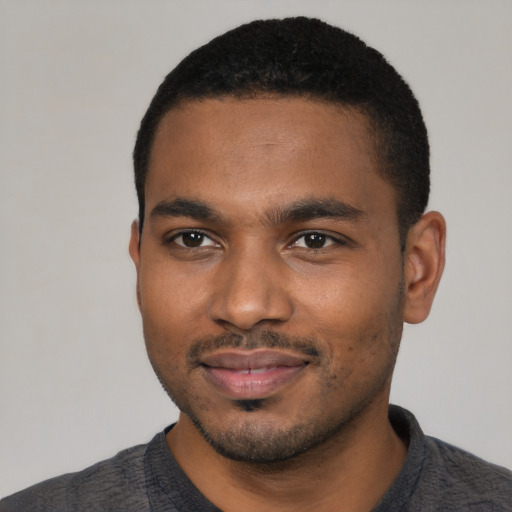 Joyful black young-adult male with short  black hair and brown eyes