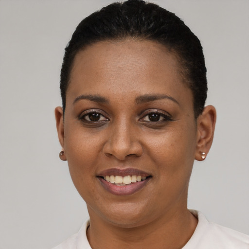 Joyful black young-adult female with short  black hair and brown eyes