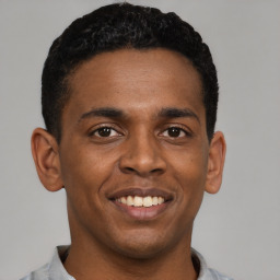 Joyful latino young-adult male with short  brown hair and brown eyes