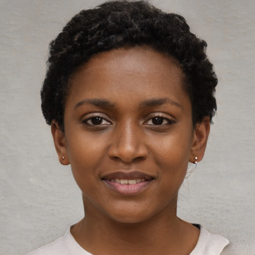 Joyful black young-adult female with short  black hair and brown eyes