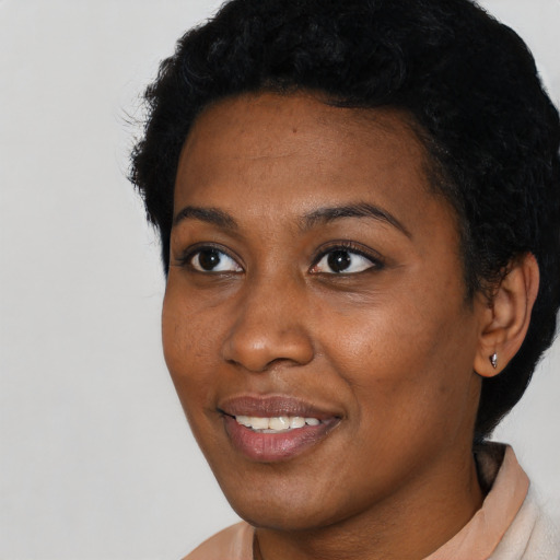 Joyful black young-adult female with short  black hair and brown eyes