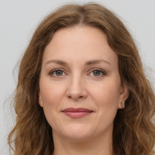 Joyful white adult female with long  brown hair and grey eyes