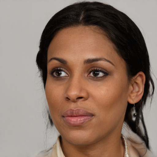 Joyful black adult female with medium  brown hair and brown eyes