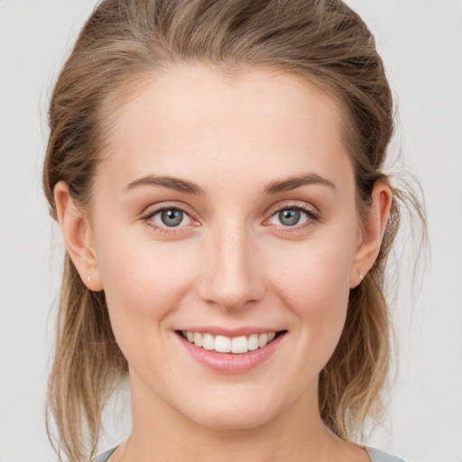 Joyful white young-adult female with medium  brown hair and grey eyes